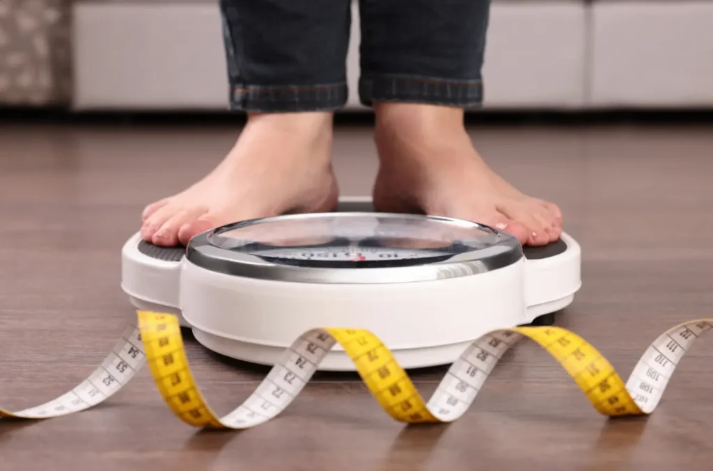 a senior getting her weight through a weighing scale for her BMI